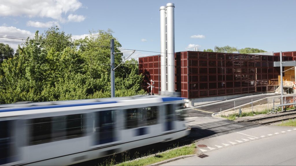 Bâtiment technique avec un tram qui passe devant